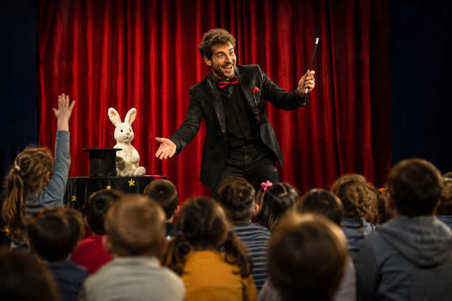 Magicien pour enfants devant un jeune public lors d’un spectacle interactif